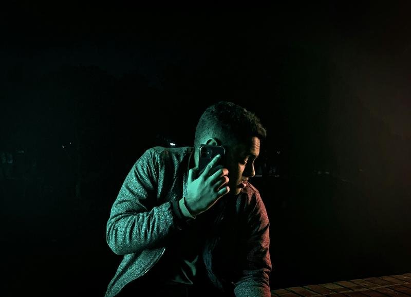 A man answering a phone call at night