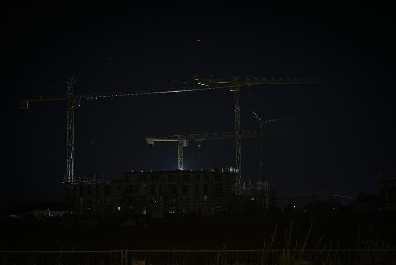 Construction cranes against the night sky