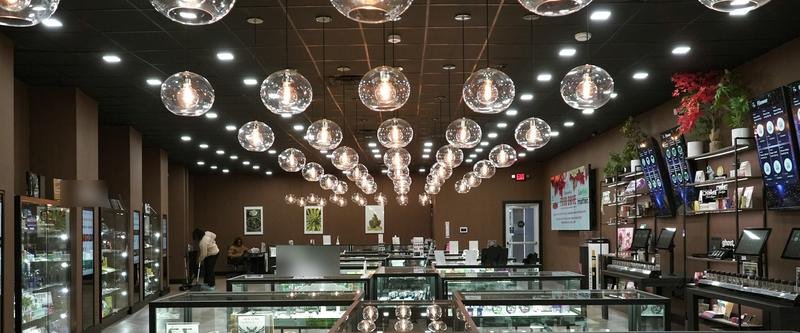 Inside a smoke and vape shop with glass display cases under pendant lights